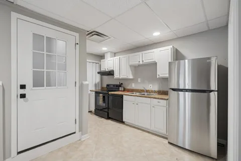 a kitchen with stainless steel appliances white cabinets and a refrigerator