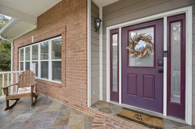 a view of a house with a door and wooden bench
