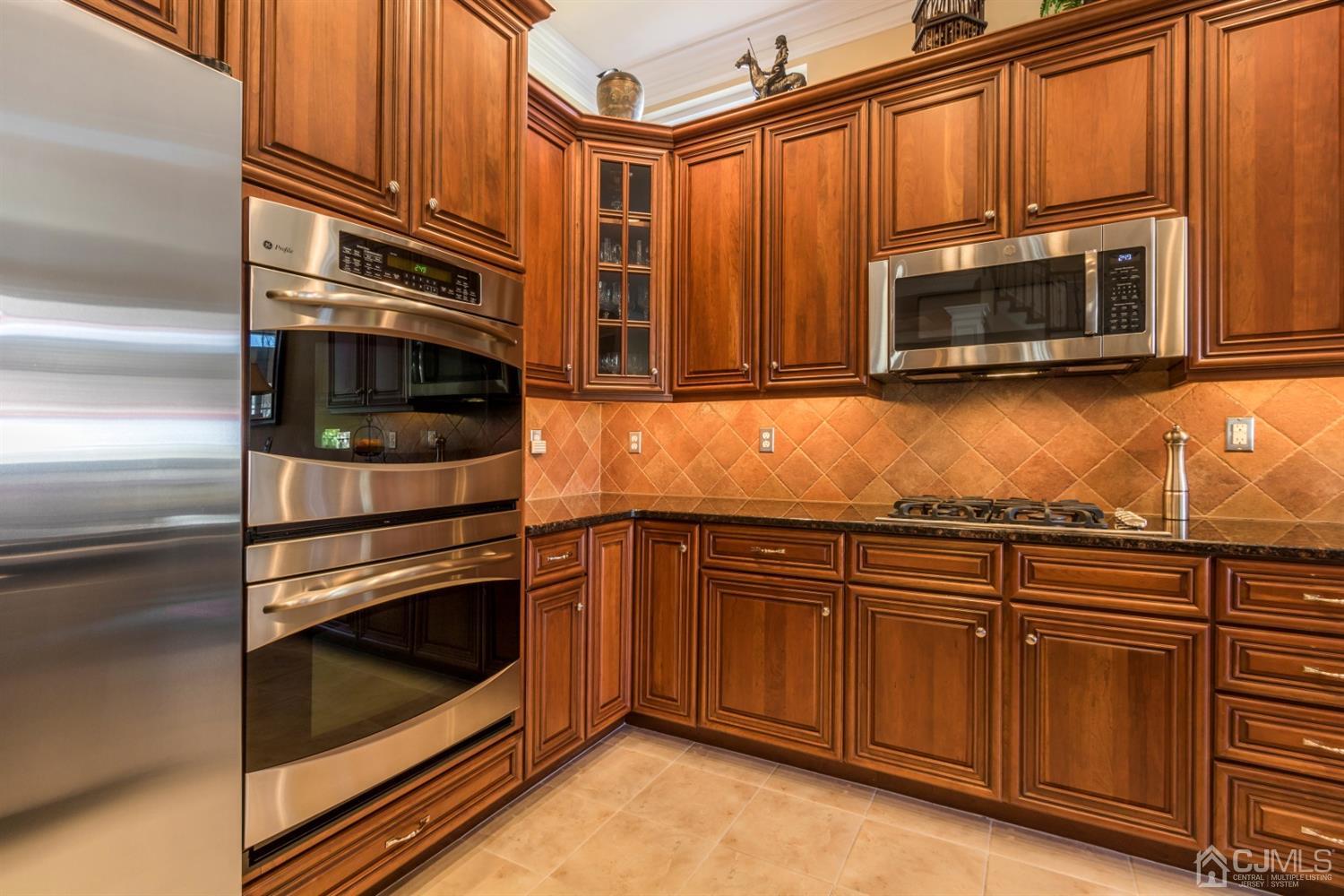 28 Kings Mill Road Monroe Township, NJ 08831 - Photo 16 of 42 a kitchen with granite countertop cabinets stainless steel appliances and wooden cabinets