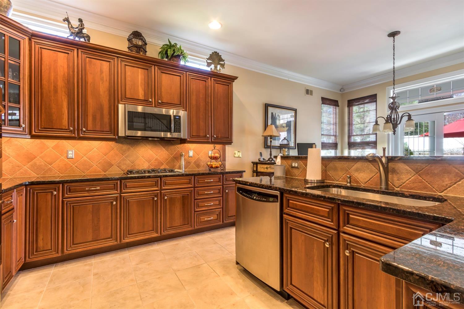 28 Kings Mill Road Monroe Township, NJ 08831 - Photo 17 of 42 a kitchen with stainless steel appliances granite countertop wooden cabinets a stove top oven a sink and dishwasher