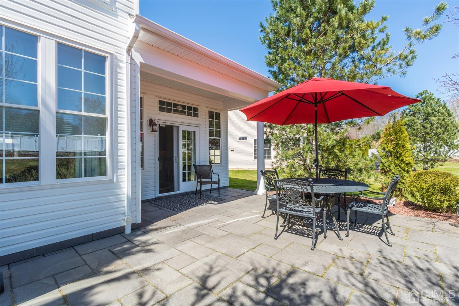 28 Kings Mill Road Monroe Township, NJ 08831 - Photo 38 of 42 a patio with a table and chairs under an umbrella