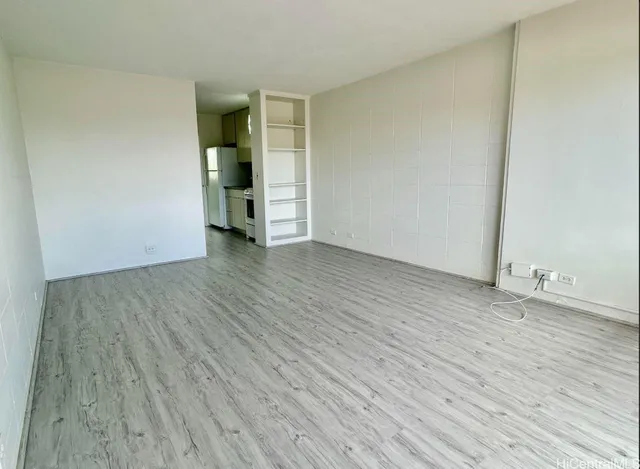 an empty room with wooden floor and closet