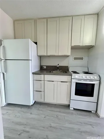 a kitchen with white cabinets and white appliances