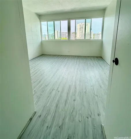 a view of an empty room window and wooden floor