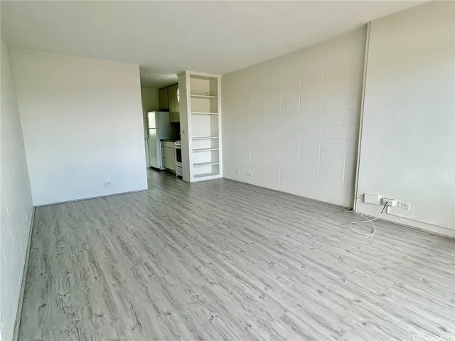 an empty room with wooden floor and closet