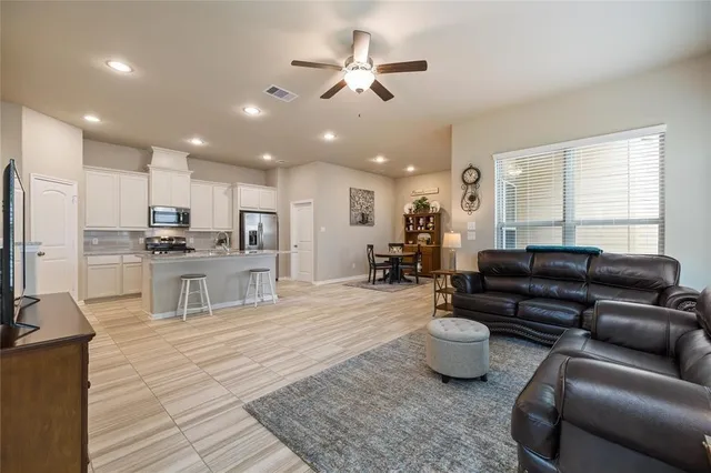 a living room with furniture kitchen view and a window