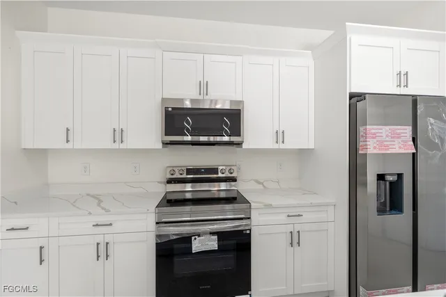 a large kitchen with kitchen island a sink stainless steel appliances and cabinets