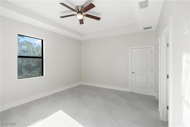 an empty room with a window and a fan
