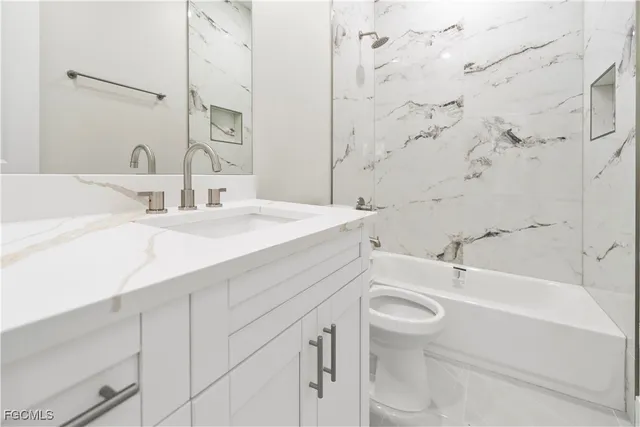 a bathroom with a sink and mirror with toilet