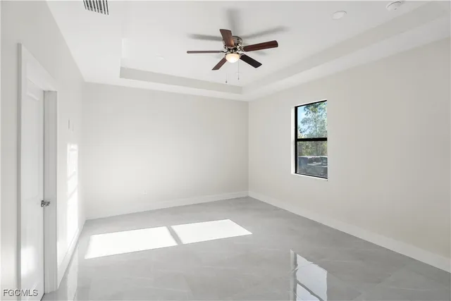 an empty room with a window and ceiling fan