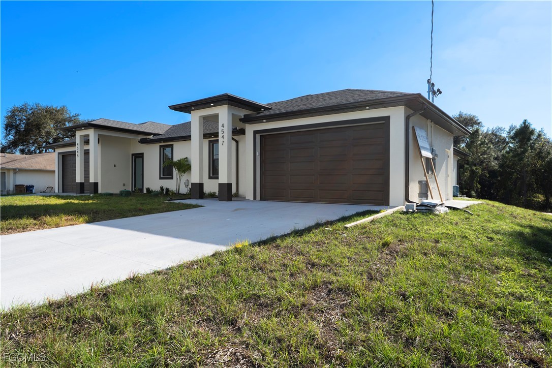 4545-4547 28th Street Southwest Lehigh Acres, FL 33973 - Photo 3 of 38 a front view of a house with a yard