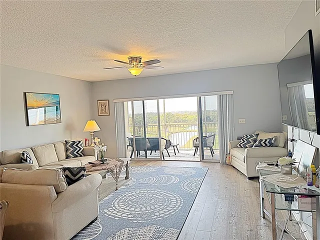 a living room with furniture a chandelier and a flat screen tv