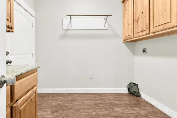 a view of a utility room with wooden floor and fan