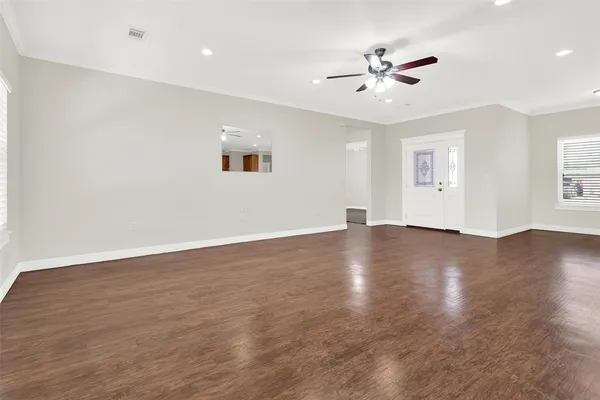 a view of a livingroom with a ceiling fan and wooden floor