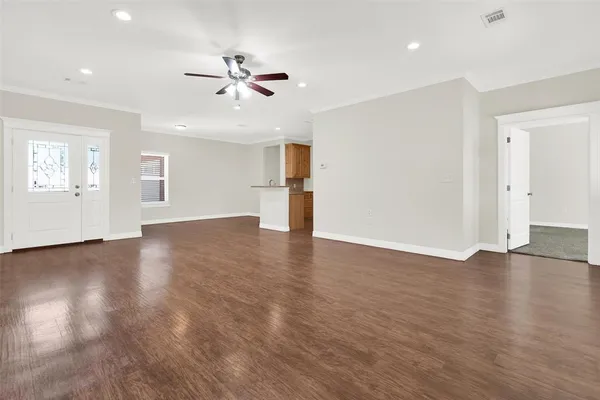 a view of a livingroom with wooden floor and ceiling fan