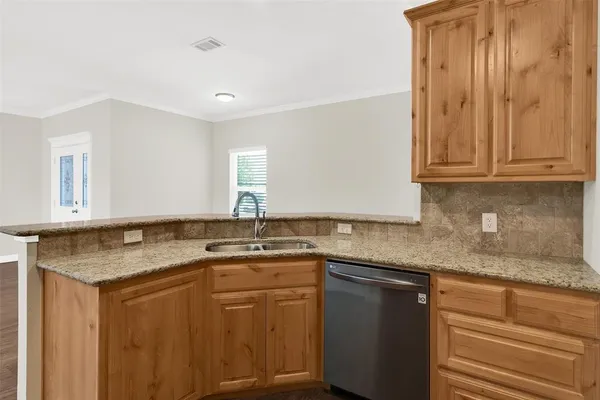 a kitchen with stainless steel appliances granite countertop a sink and dishwasher with wooden cabinets