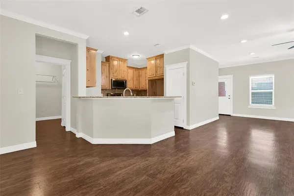 a view of a kitchen with wooden floor and electronic appliances