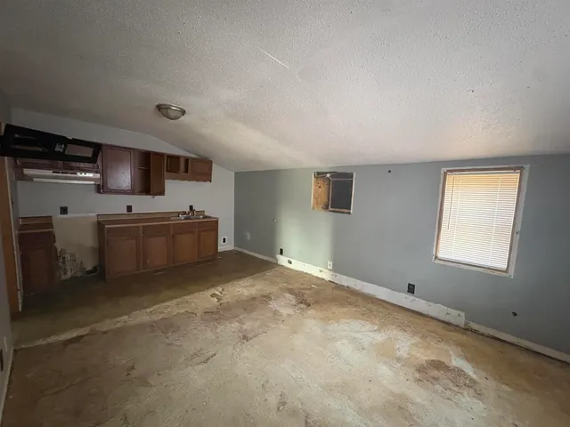 a view of a livingroom with furniture kitchen and a window