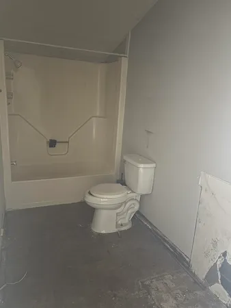 a white toilet sitting next to a bath tub