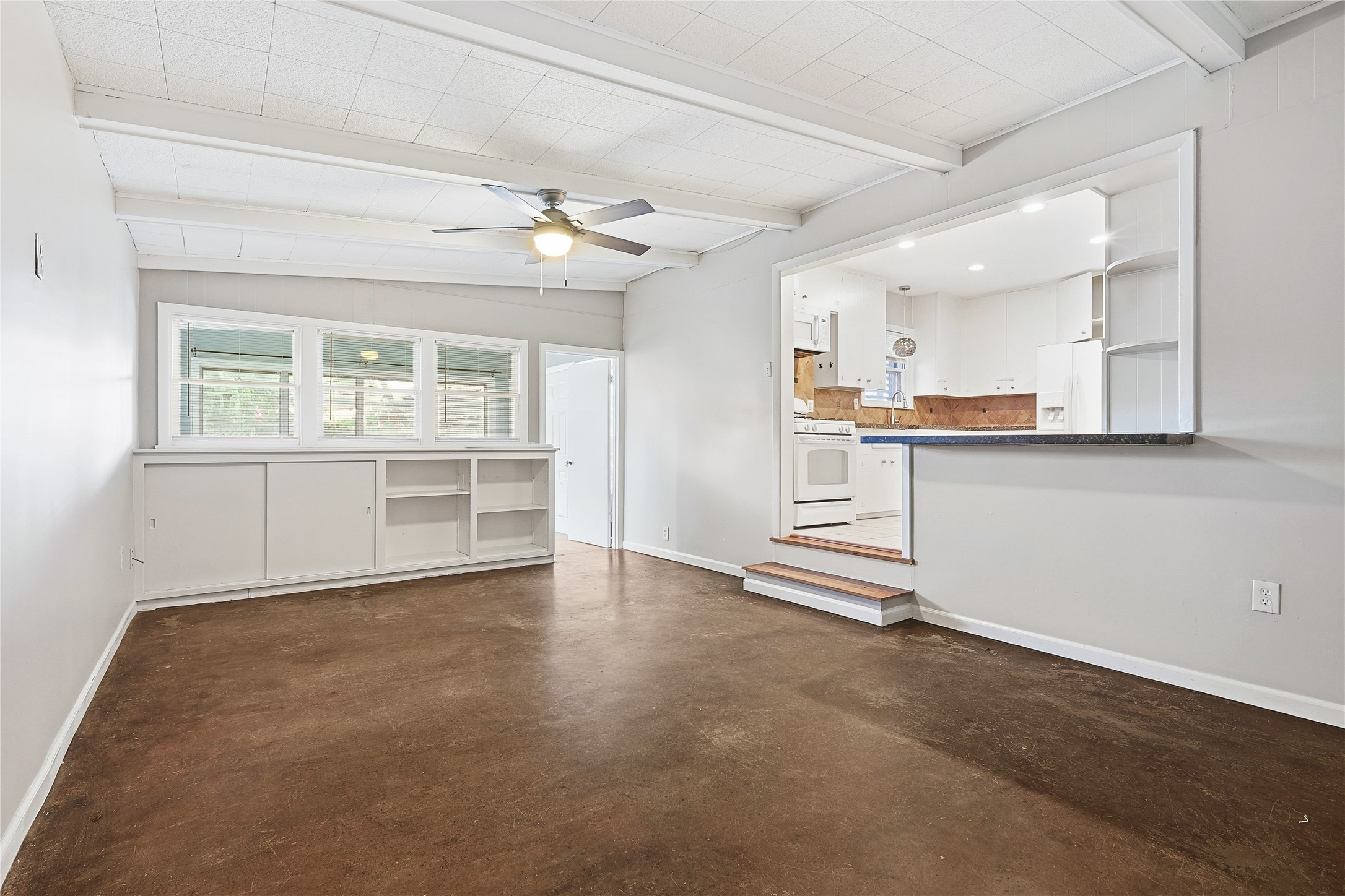 106 Trout Avenue Galveston, TX 77550 - Photo 11 of 21 an empty room with a kitchen and windows