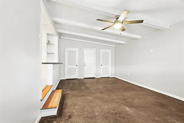 an empty room with closet and fan