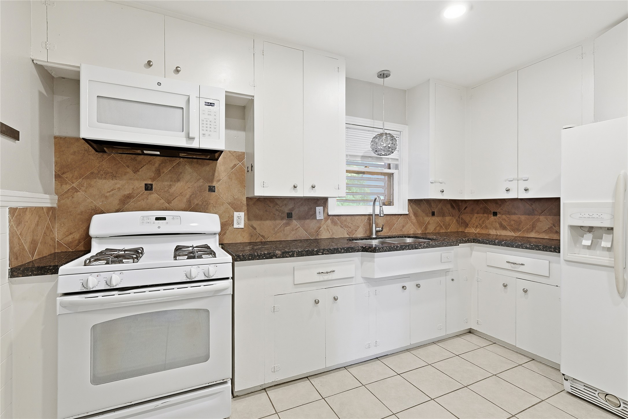 106 Trout Avenue Galveston, TX 77550 - Photo 8 of 21 a kitchen with white cabinets appliances and sink