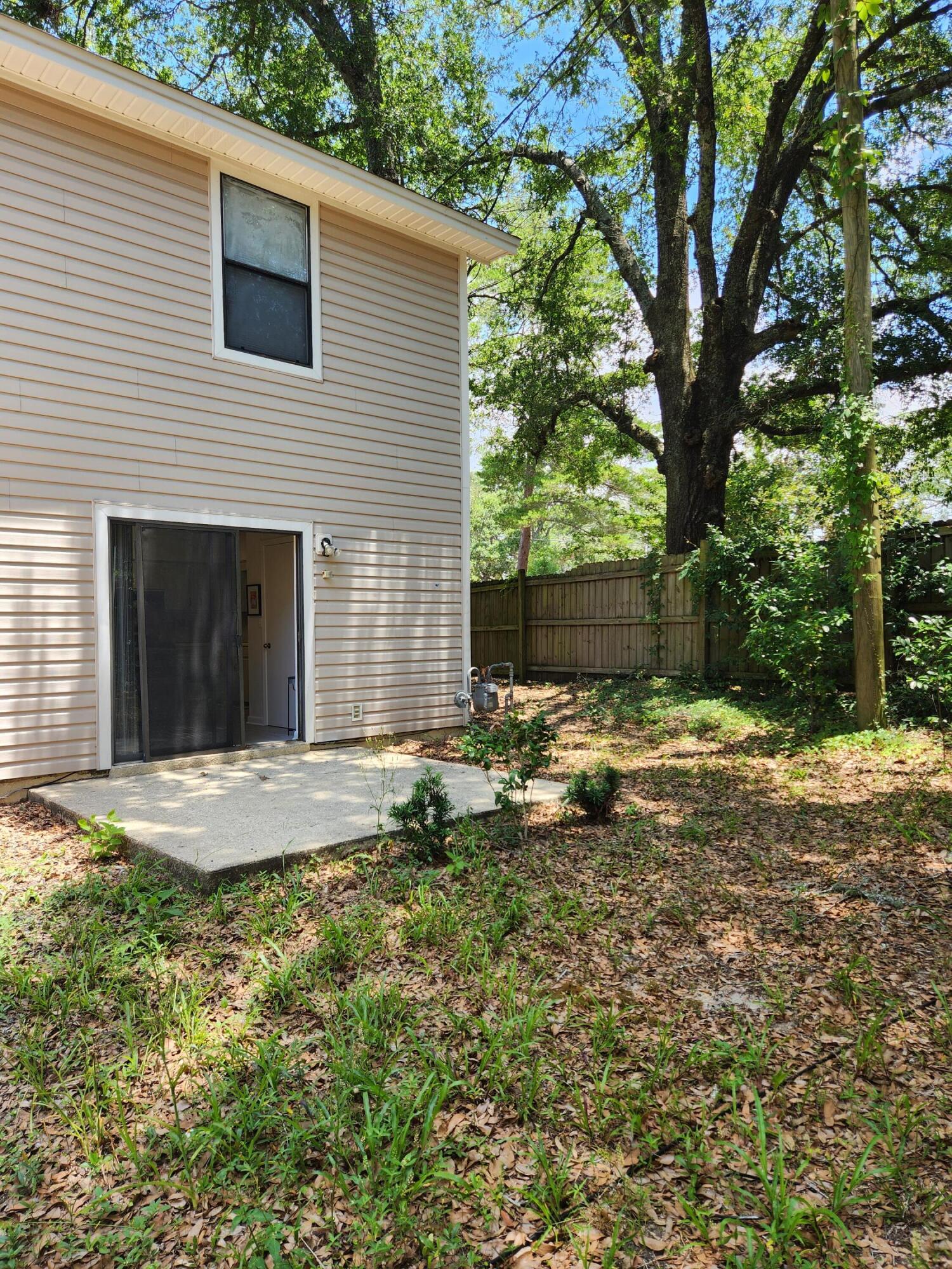 205 Marquette Avenue, Unit 1 Niceville, FL 32578 - Photo 16 of 16 a backyard of a house with table and chairs