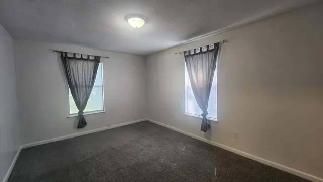 an empty room with windows and closet