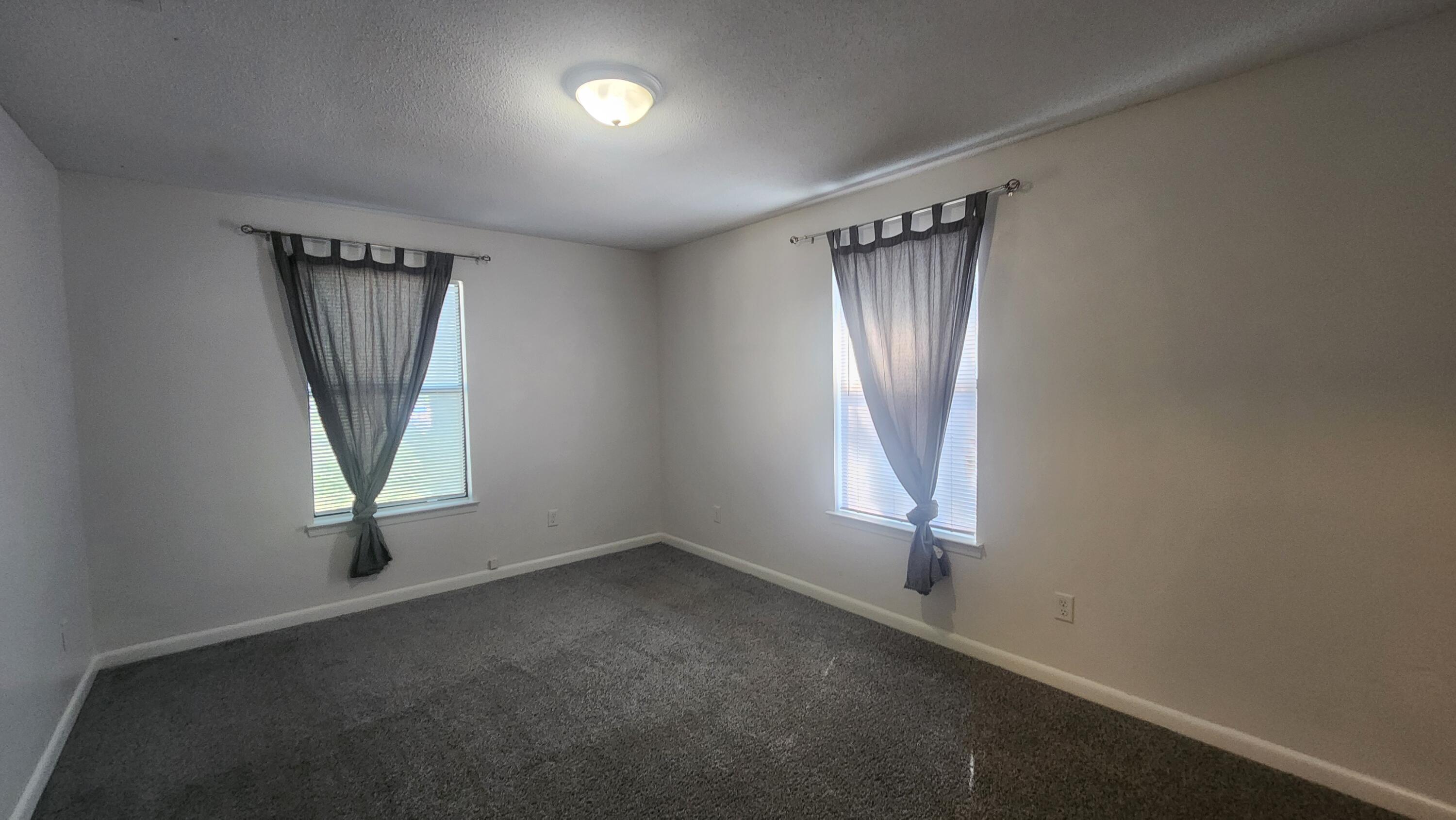 205 Marquette Avenue, Unit 1 Niceville, FL 32578 - Photo 4 of 16 an empty room with windows and closet