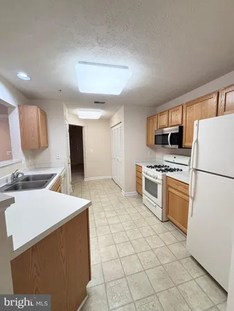a kitchen with a stove a sink and a refrigerator