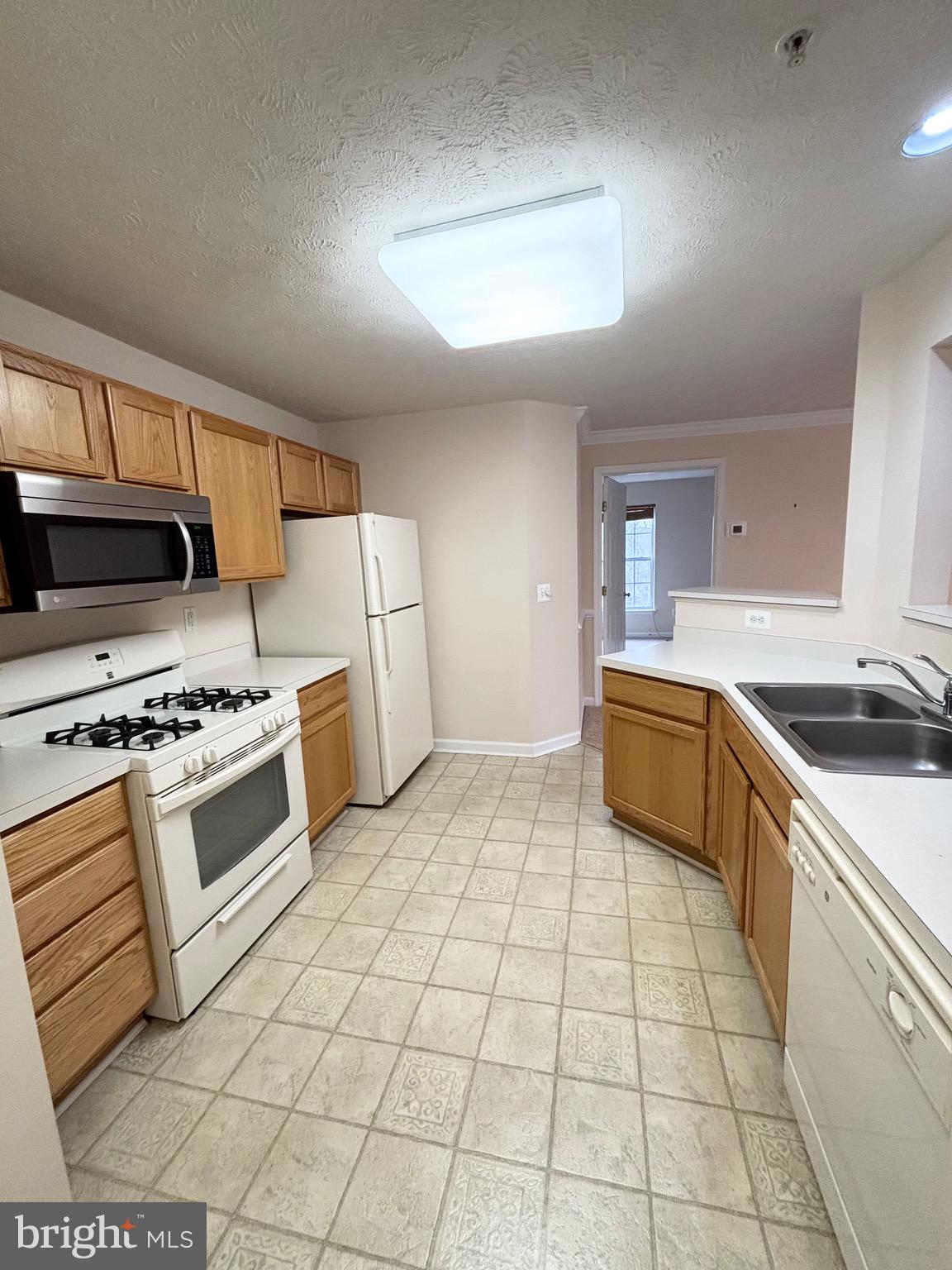 5014 Marchwood Court, Unit 7F Perry Hall, MD 21128 - Photo 15 of 16 a kitchen with a stove a sink and a refrigerator