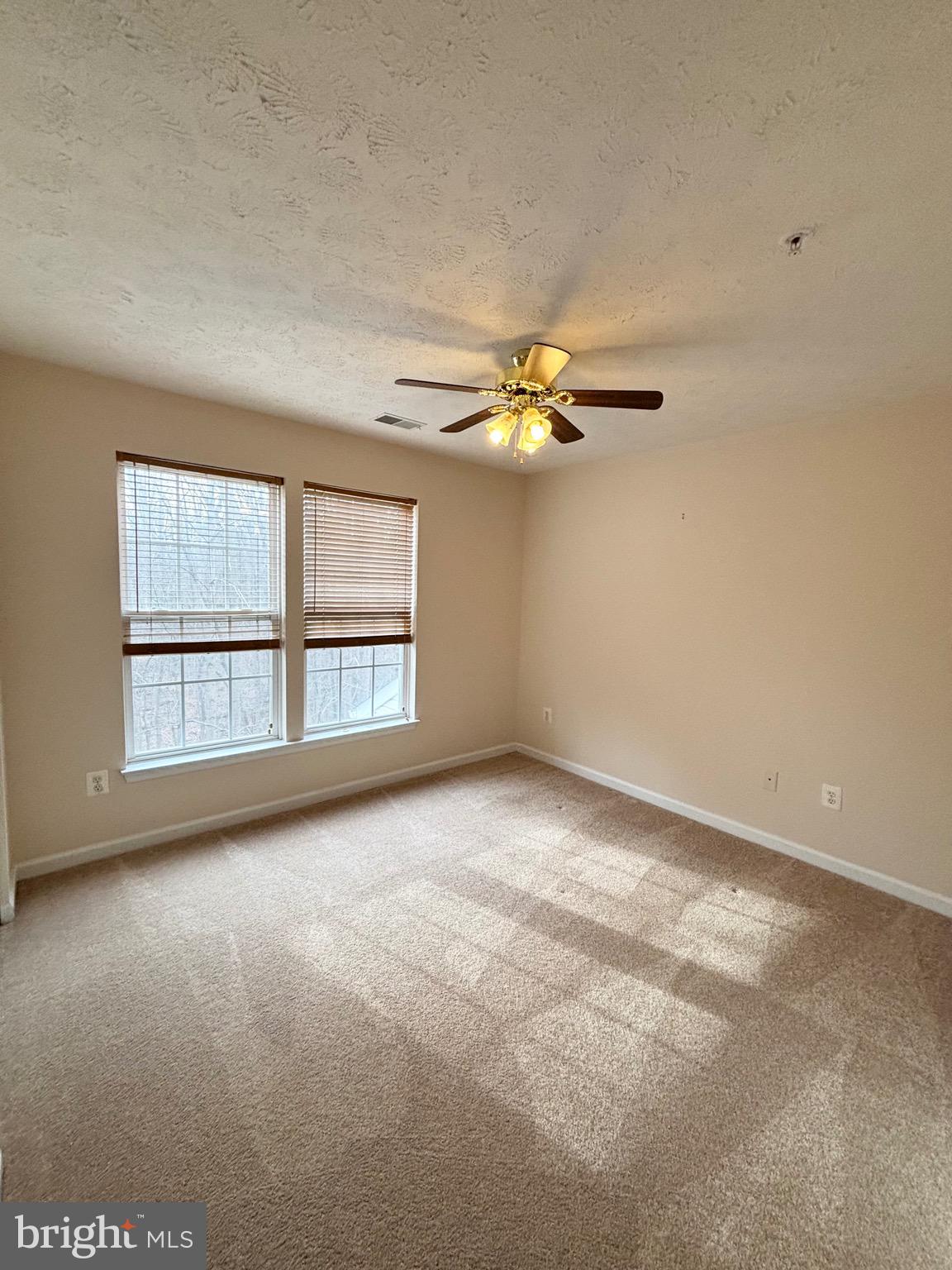 5014 Marchwood Court, Unit 7F Perry Hall, MD 21128 - Photo 6 of 16 an empty room with windows and chandelier fan