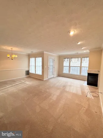a view of an empty room with a window and fireplace