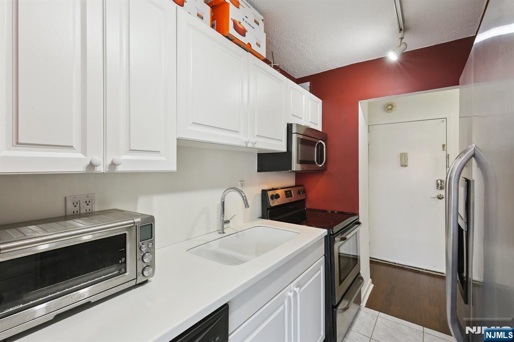 125 Prospect Avenue, Unit 17G Hackensack, NJ 07601 - Photo 13 of 30 a kitchen with stainless steel appliances a stove a sink and a refrigerator