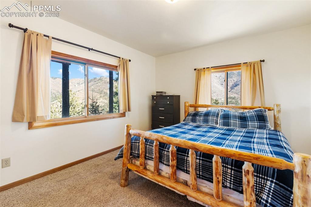 9110 Mountain Road Cascade, CO 80809 - Photo 27 of 49 a bedroom with a bed next to a window