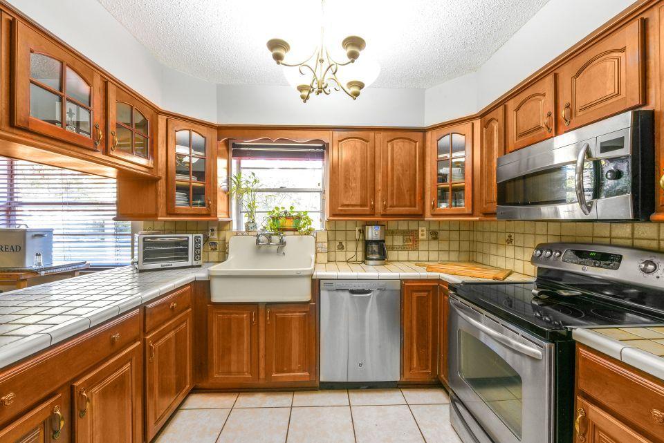 3196 Gulfstream Road Palm Springs, FL 33461 - Photo 8 of 26 a kitchen with stainless steel appliances a stove sink microwave and cabinets