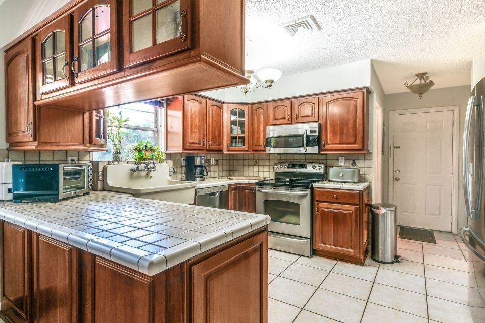 3196 Gulfstream Road Palm Springs, FL 33461 - Photo 10 of 26 a kitchen with stainless steel appliances granite countertop a stove a sink and a refrigerator