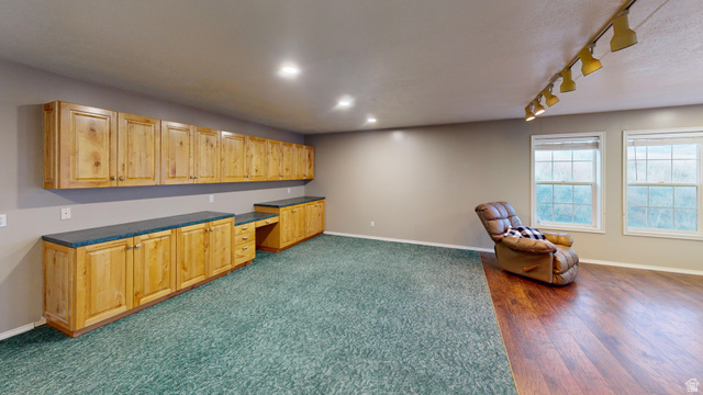 9029 North Treasureton Road Preston, ID 83263 - Photo 31 of 31 Kitchen with built in study area, dark countertops, track lighting, open floor plan, and light brown cabinetry