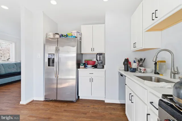 a kitchen with stainless steel appliances a refrigerator sink and cabinets