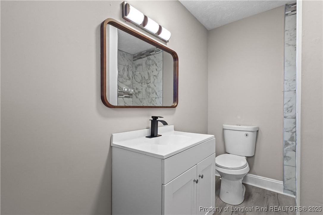2302 Odom Road Hope Mills, NC 28348 - Photo 13 of 33 a bathroom with a toilet sink and mirror