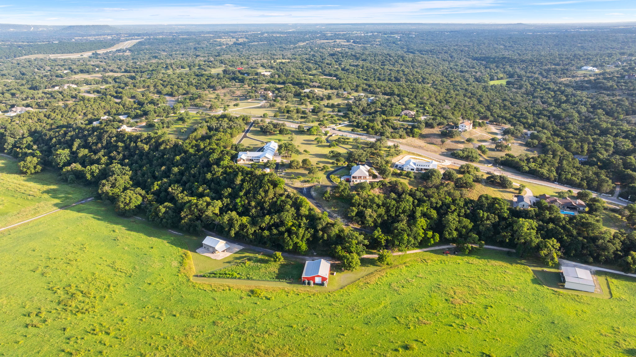 1427 River Ridge Ranch Road Killeen, TX 76549 - Photo 37 of 40 An aerial panorama reveals a vast, tree-filled landscape dotted with secluded homes and open green fields.