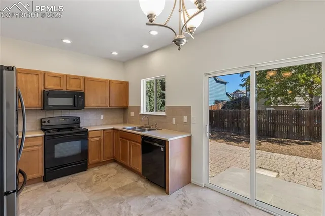 a kitchen with stainless steel appliances granite countertop a stove top oven a sink and a refrigerator