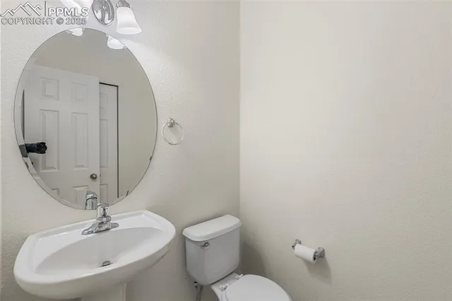 a bathroom with a toilet a sink and mirror