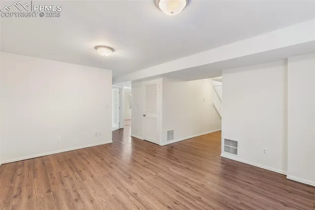a view of an empty room with wooden floor