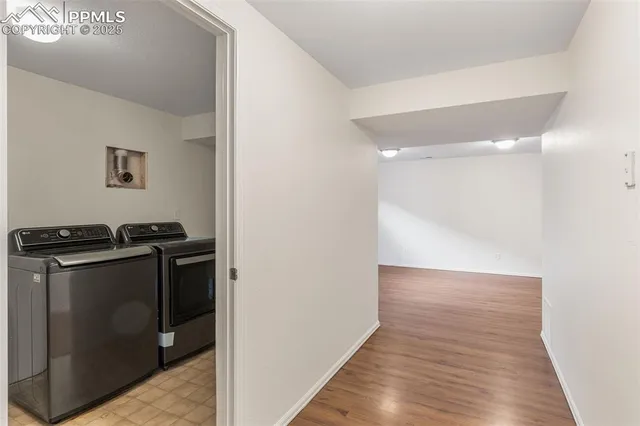a view of an empty room with wooden floor