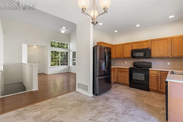 a kitchen with stainless steel appliances granite countertop a refrigerator a stove a sink and a microwave