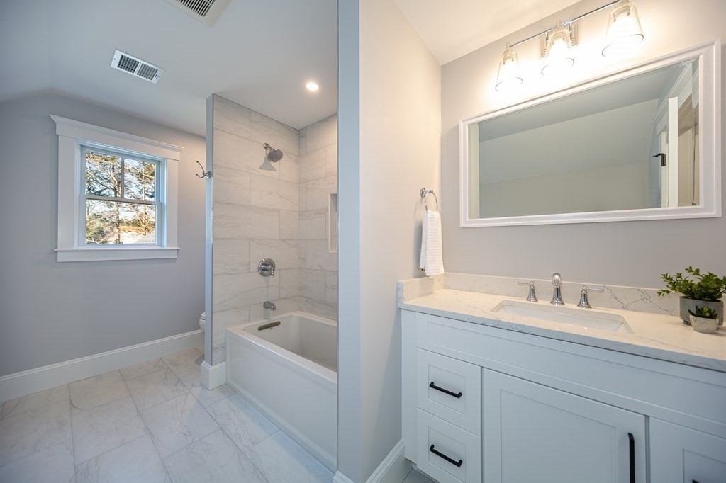 4 Whitcomb Street Natick, MA 01760 - Photo 32 of 42 a bathroom with a bathtub a mirror a sink and vanity