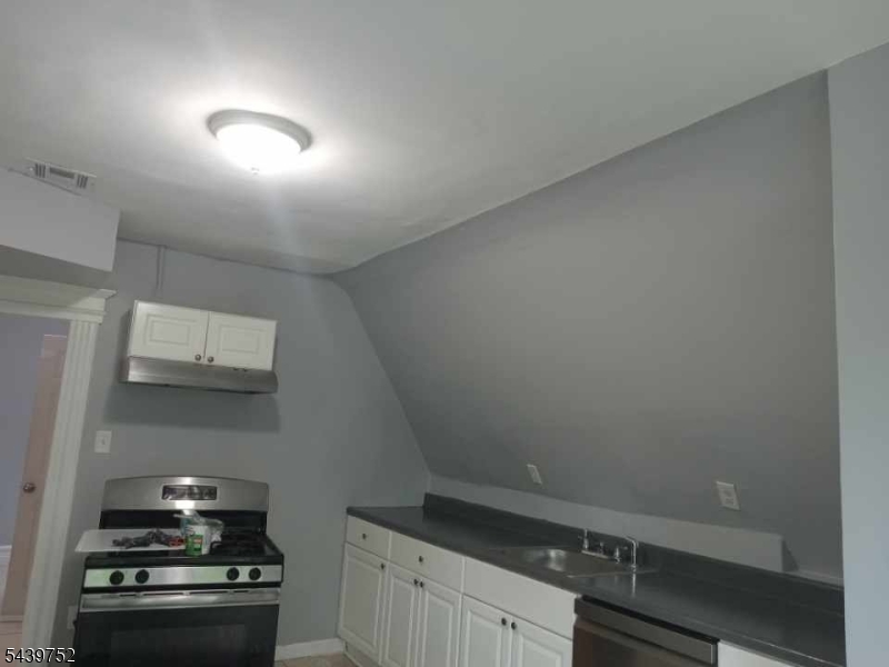 58 North 5th Street, Unit 3 Newark, NJ 07107 - Photo 9 of 11 a kitchen with a stove and cabinets