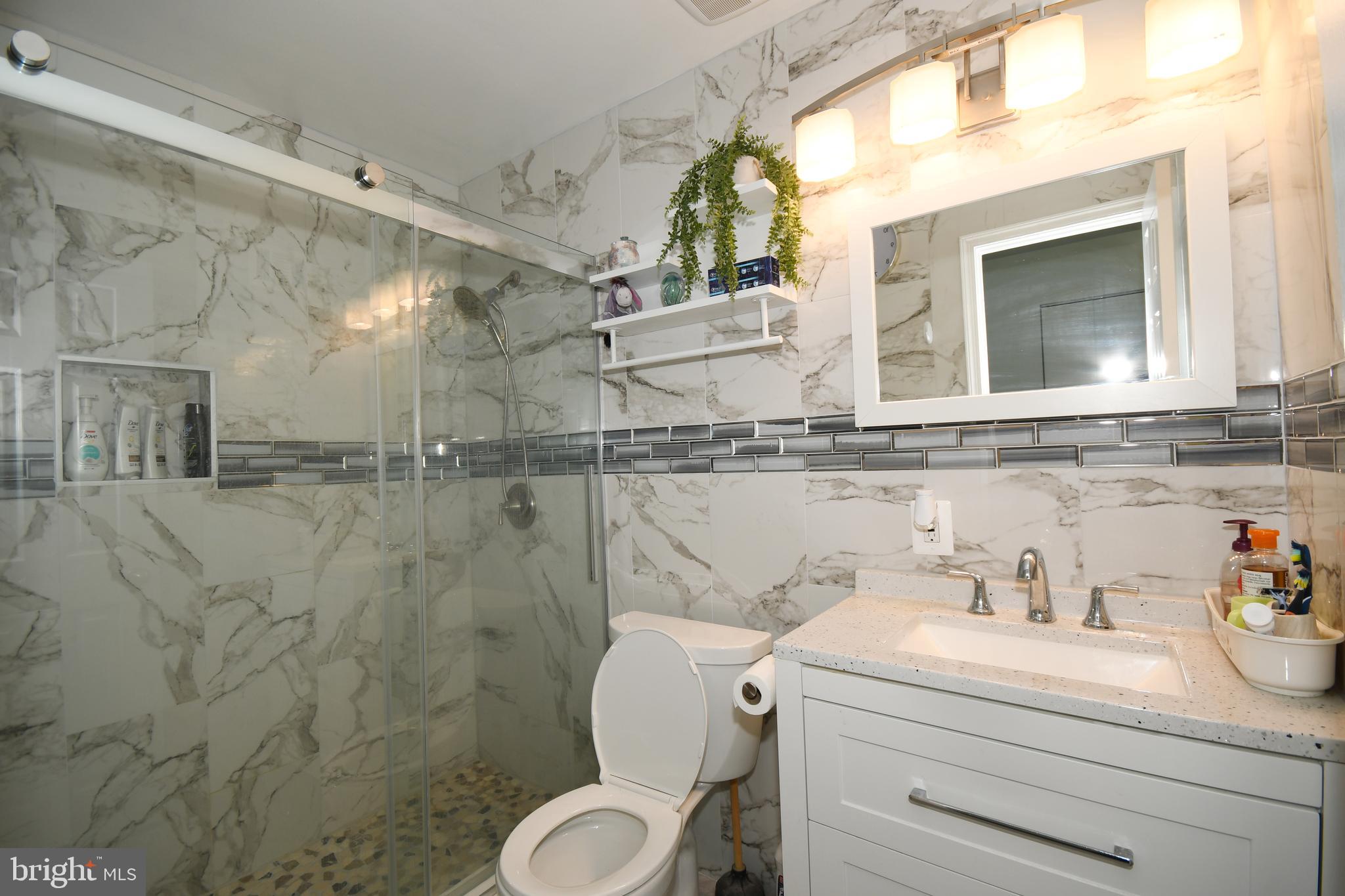 1402 Mullins Street Silver Spring, MD 20904 - Photo 14 of 29 a bathroom with a granite countertop sink mirror vanity and toilet