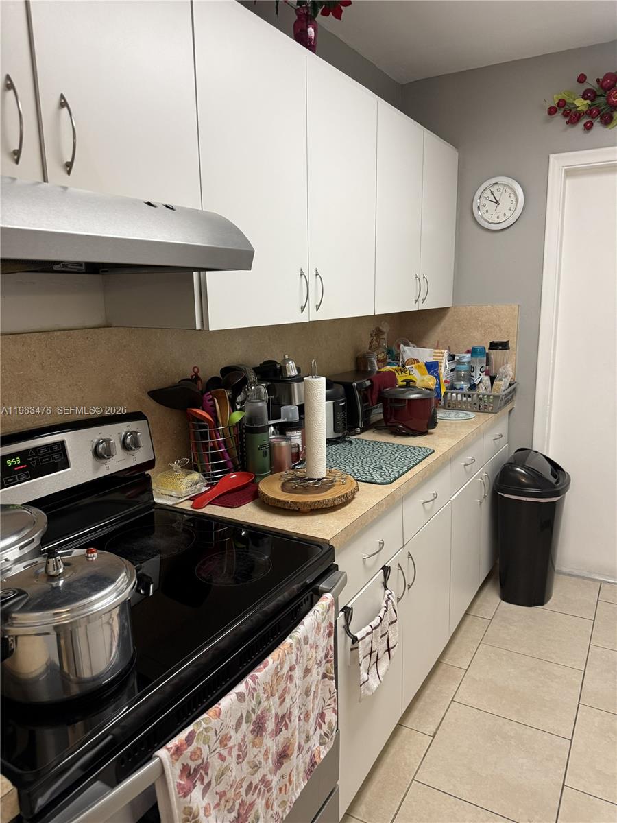 7845 Miller Drive, Unit A204 Miami, FL 33155 - Photo 2 of 6 a kitchen with a stove and a microwave